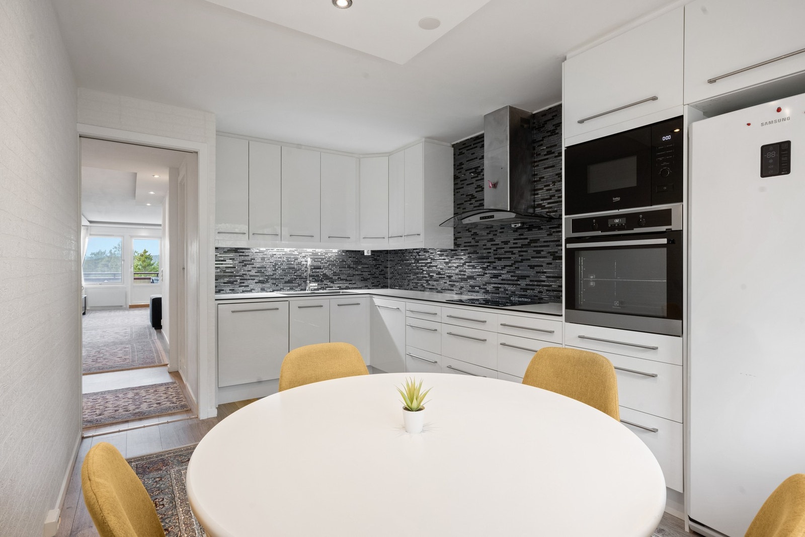 Pent kjøkken som har godt med skap- og benkeplass. Galleribilde