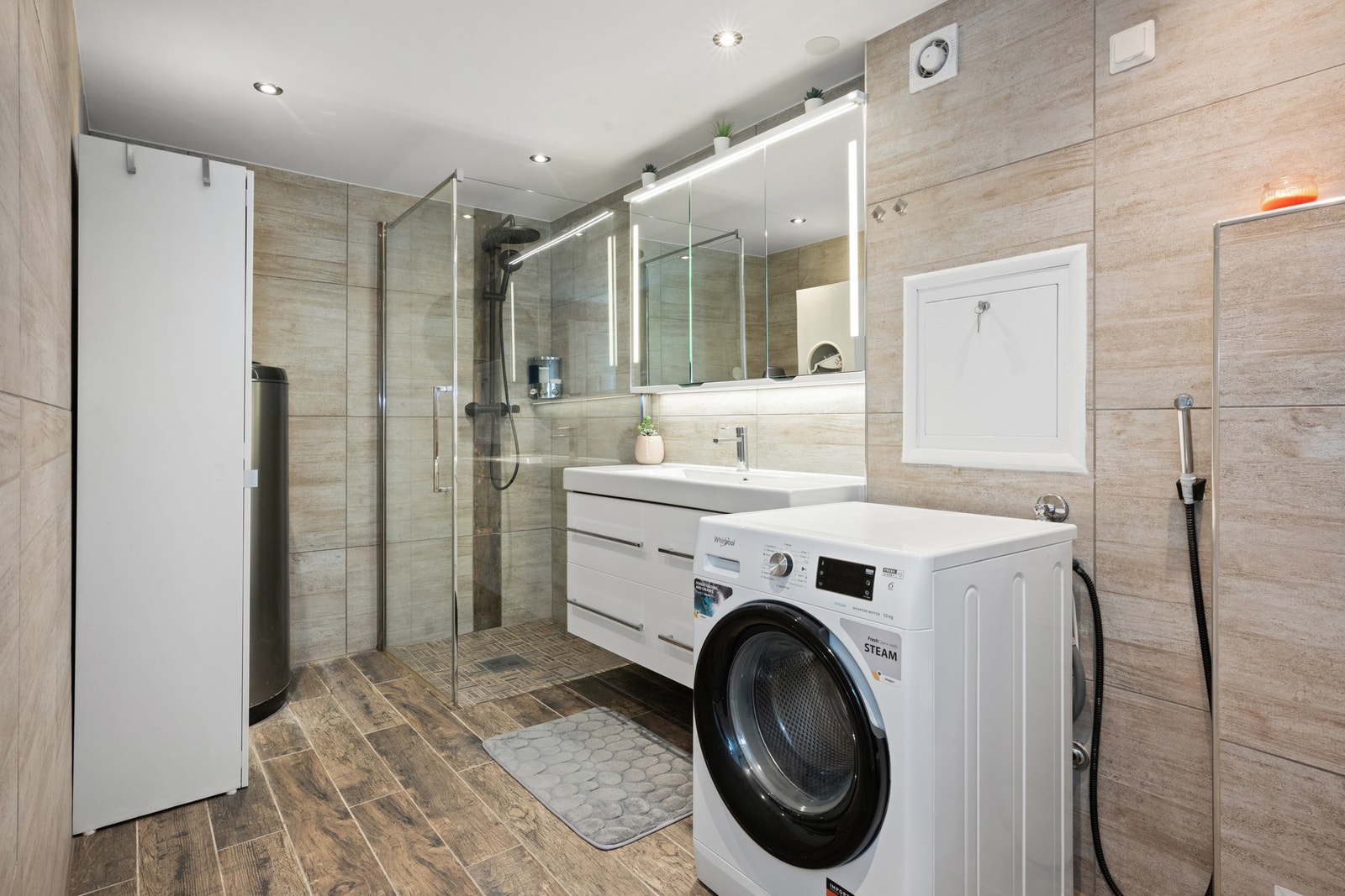 Lekkert flislagt bad med opplegg for vaskemaskin. Galleribilde