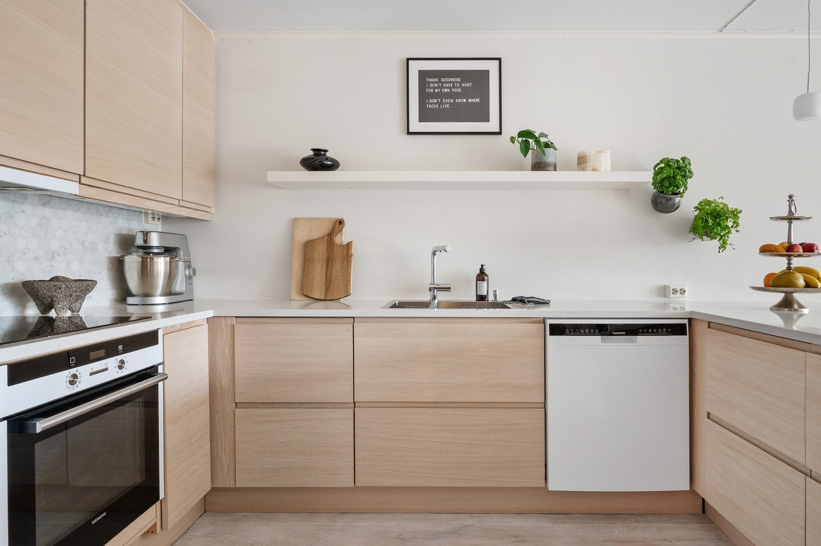 Kjøkkenet er gjennomført i et moderne og lyst design med naturlige trematerialer. Galleribilde