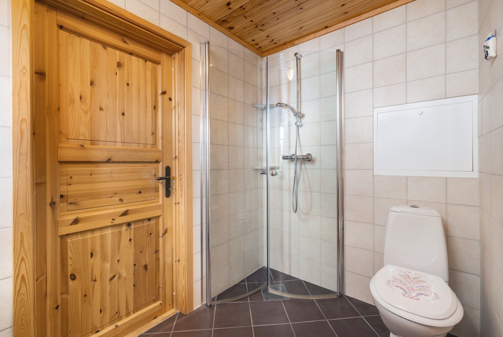 Flislagt gulv hvor det er gulvvarme. Det er fliser på vegger og trepanel i himling. Galleribilde