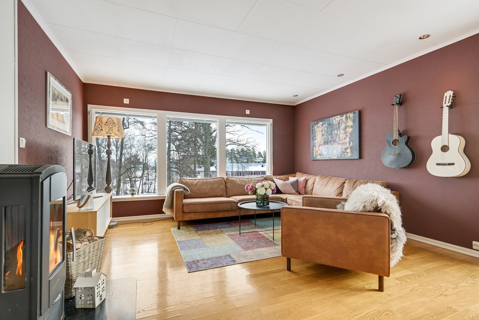 Stue i hovedetasje med vedovn og sjøgløtt. Galleribilde