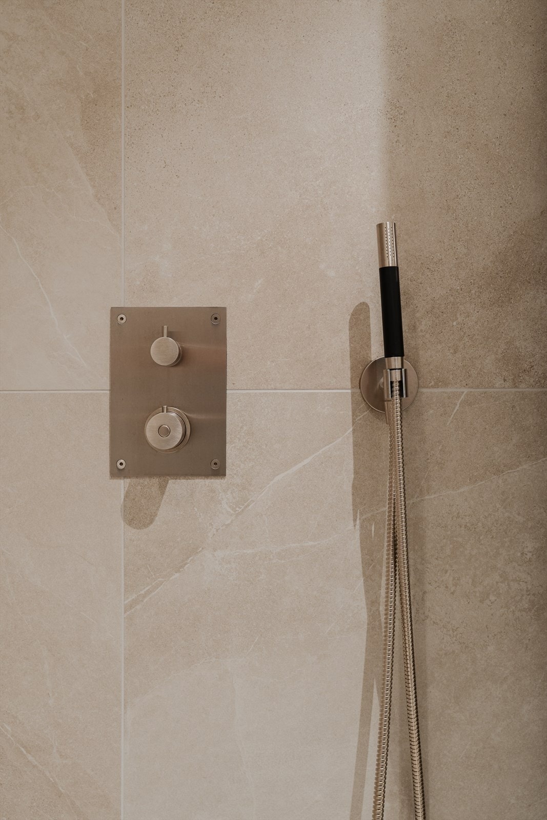 Dusj med skillevegg i herdet glass, servant i rustfritt stål, veggfestet klosett med innebygget sisterne og opplegg for vaskemaskin Galleribilde