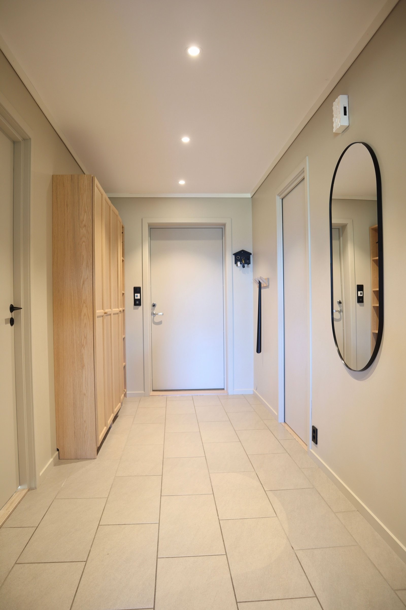 Hall med fliser på gulv og varmekabler. Her er det god plass for alt av yttertøy. Fra hallen er det tilkomst til soverom, vaskerom og bad. Galleribilde