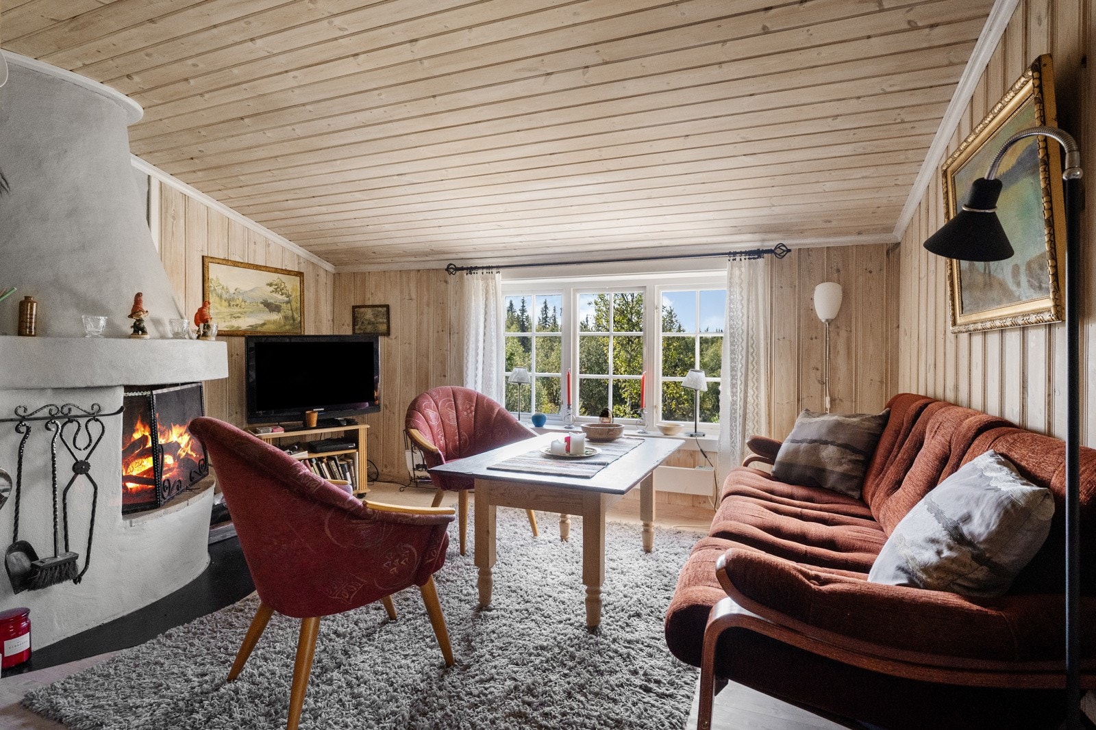 Stuen har vinduer med fin utsikt mot fjell og vakker natur, som gir en følelse av nærhet til omgivelsene og ro i hverdagen. Galleribilde