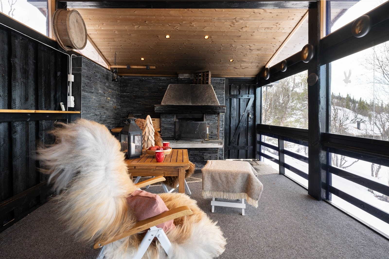 Flott ute-stue med peis, og skyvedører som kan åpnes og lukkes alt etter som været tillater. Galleribilde