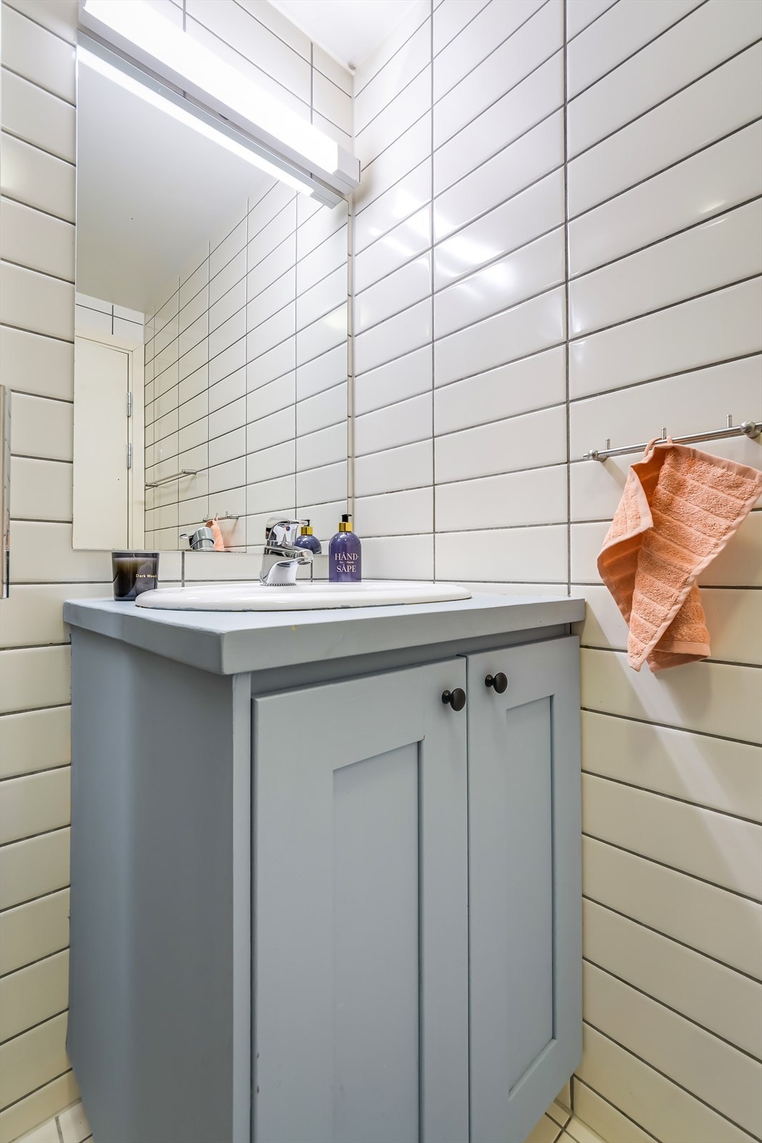 Innredningen består av servant med underskap, speil med innredet lys, dusj med skyvedør og toalett Galleribilde