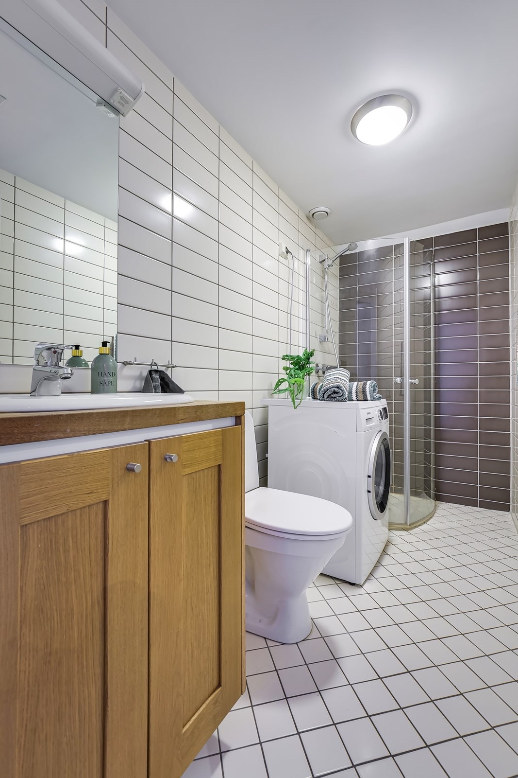 Pent flislagt bad med gulvvarme og opplegg for vaskemaskin Galleribilde