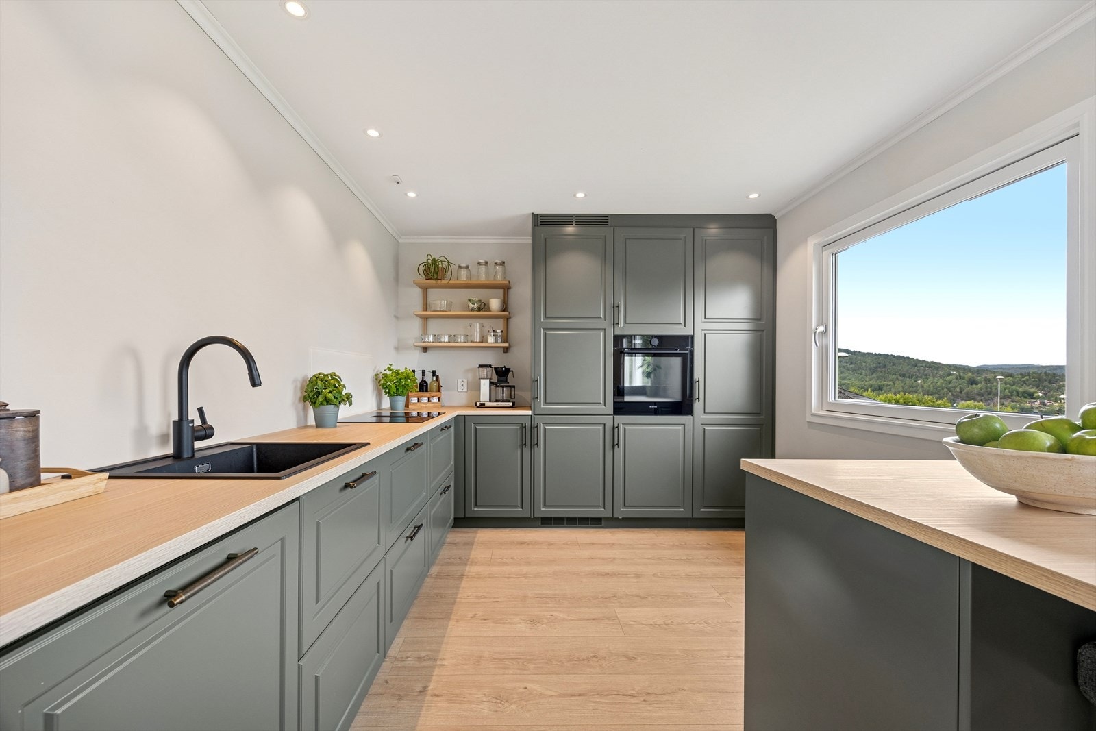 Stekeovn, induksjonstopp med kullfilterventilator, kjøl/frys og oppvaskmaskin er integrert i innredningen. Galleribilde