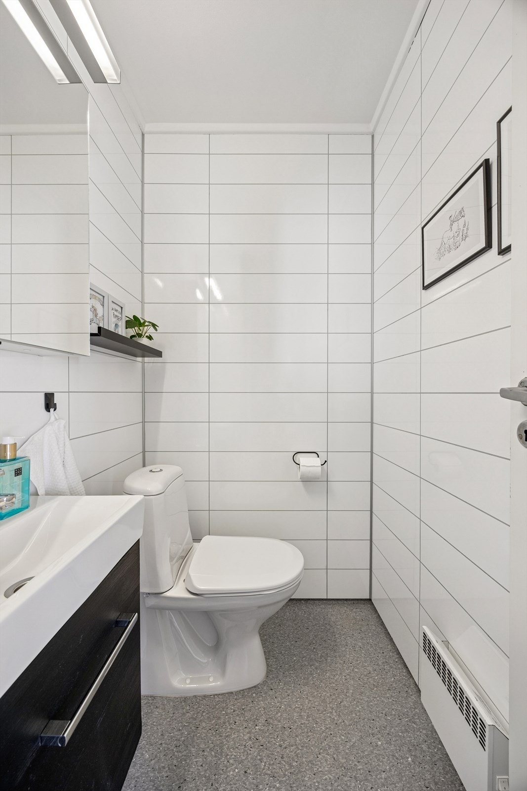 Vegg i vegg med vaskerommet har boligen et separat toalettrom med vinylbelegg på gulv og vegger med våtromsplater. Galleribilde