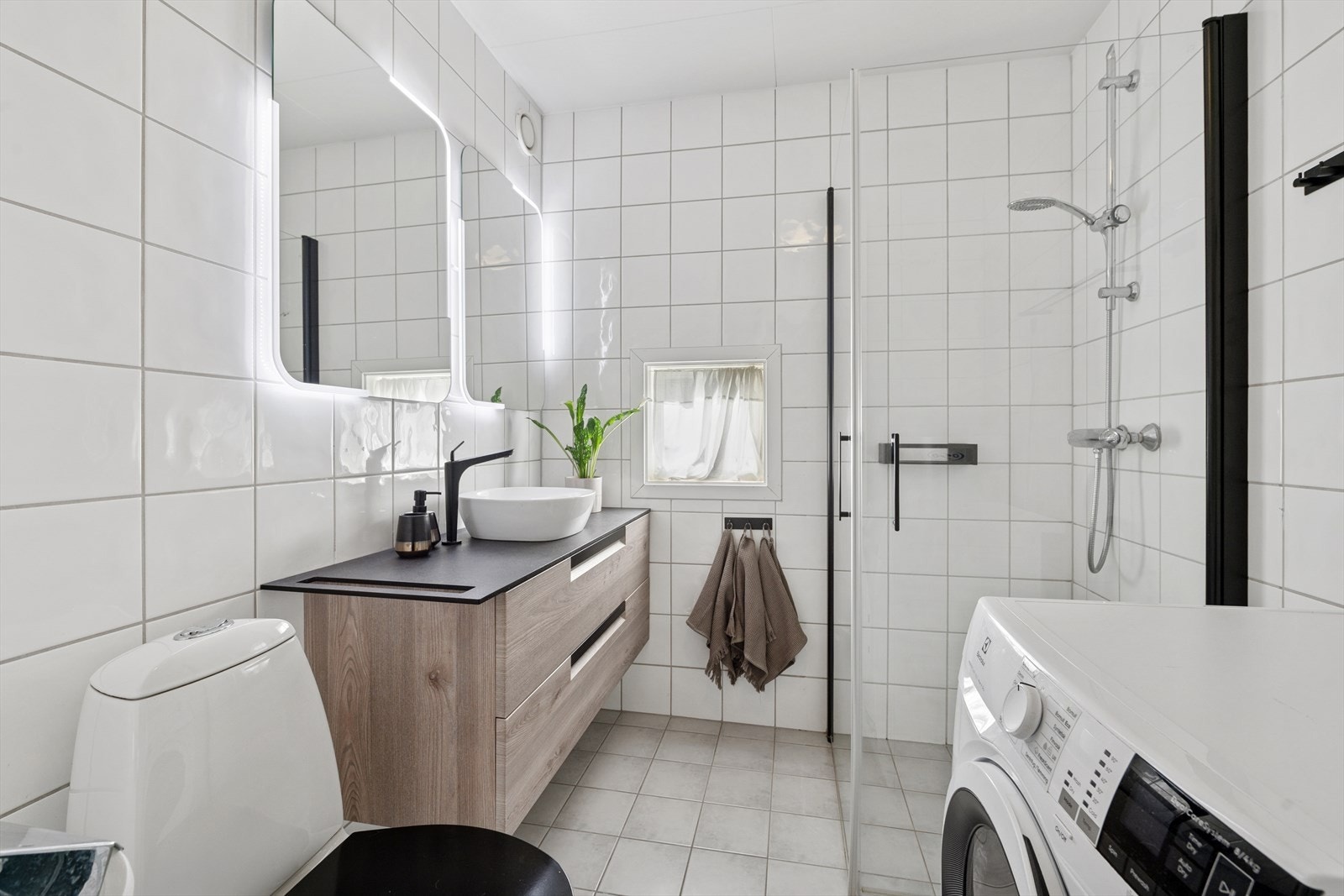 Delikat flislagt bad med flislagte overflater på gulv og vegger. Galleribilde