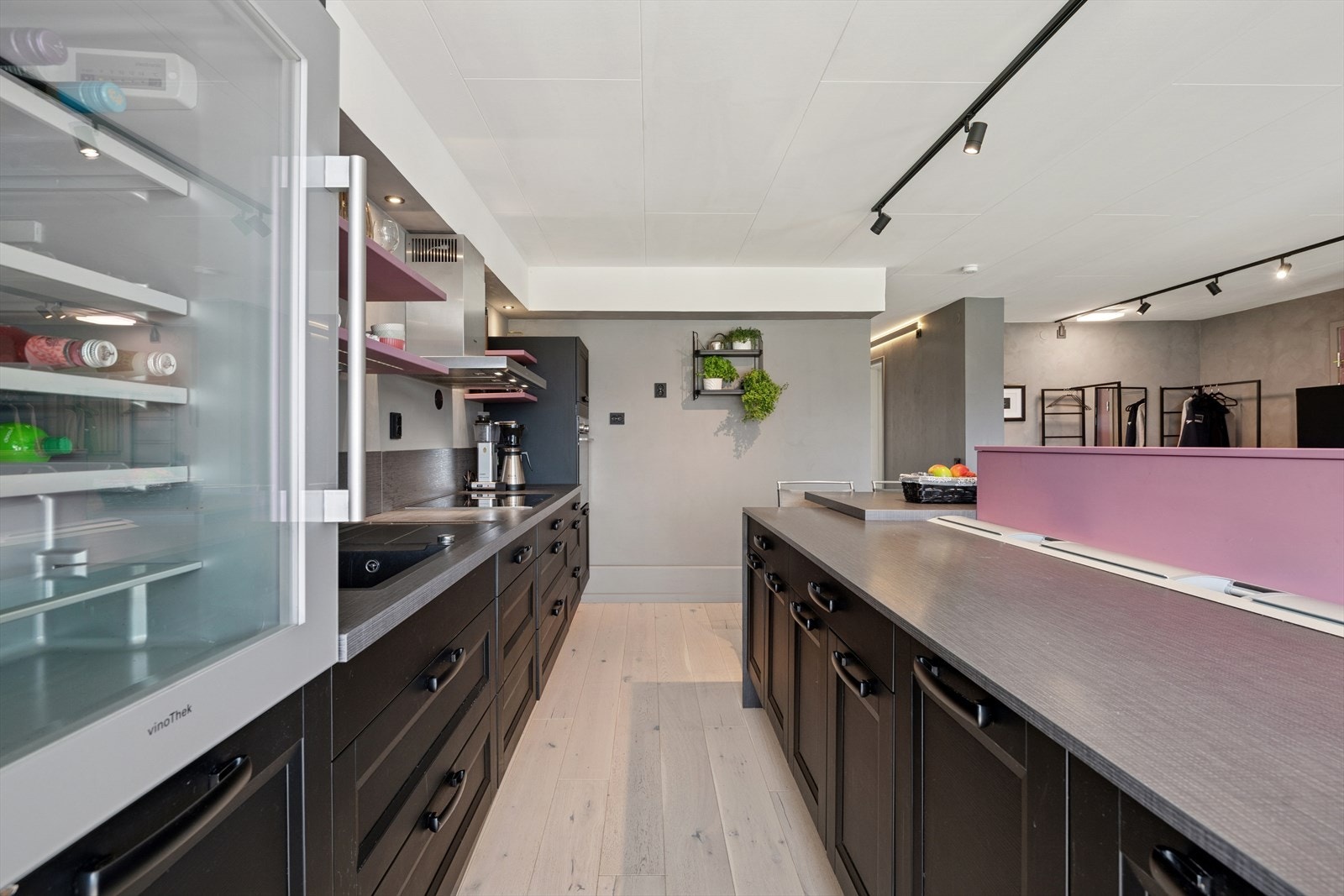 Stilrent kjøkken med integrert stekeovn, platetopp, oppvaskmaskin, vinskap og kjøl/frys. Galleribilde