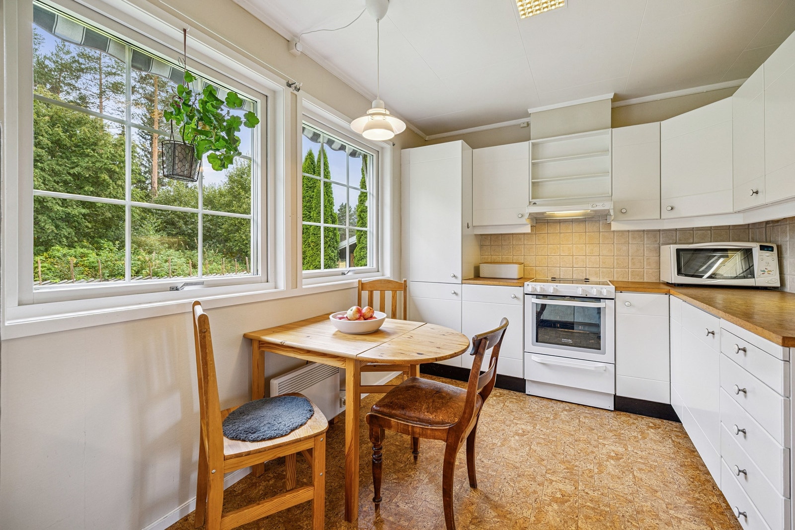 Kjøkkenet har en hyggelig spiseplass ved vinduet Galleribilde