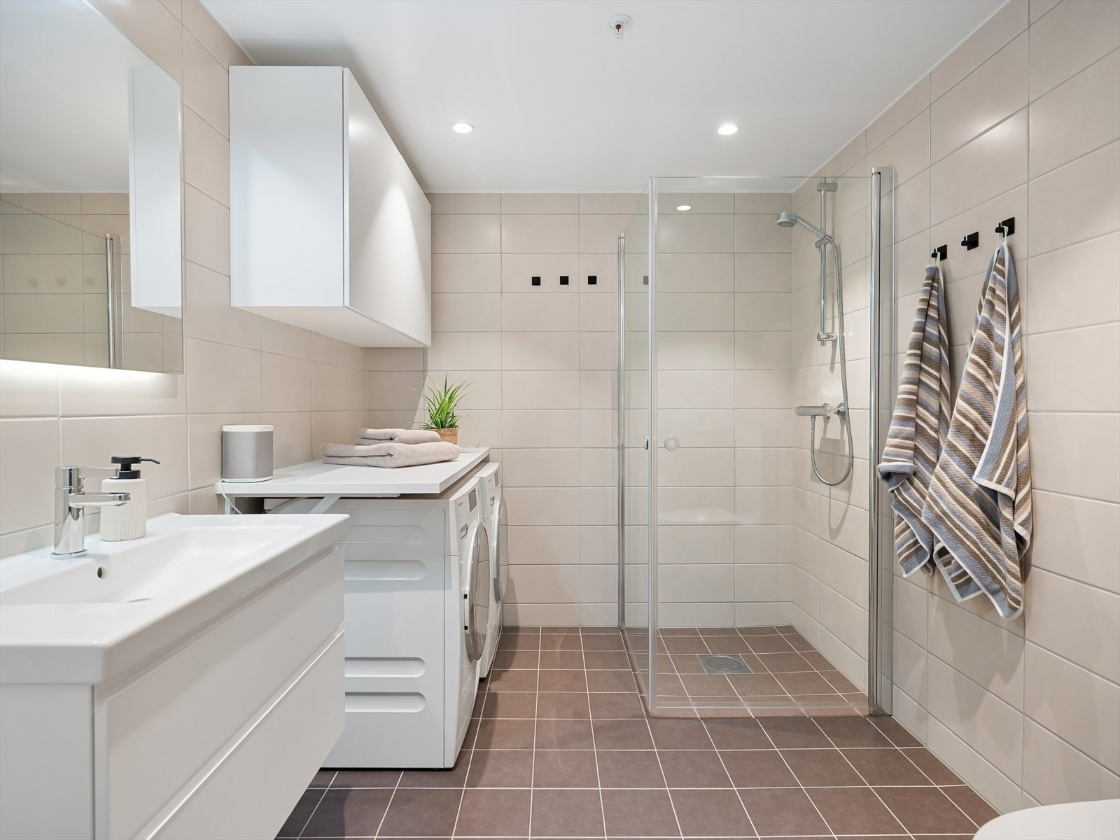 Opplegg for vaskemaskin og plass til tørketrommel. Praktisk med benkeplate og skap over. Galleribilde