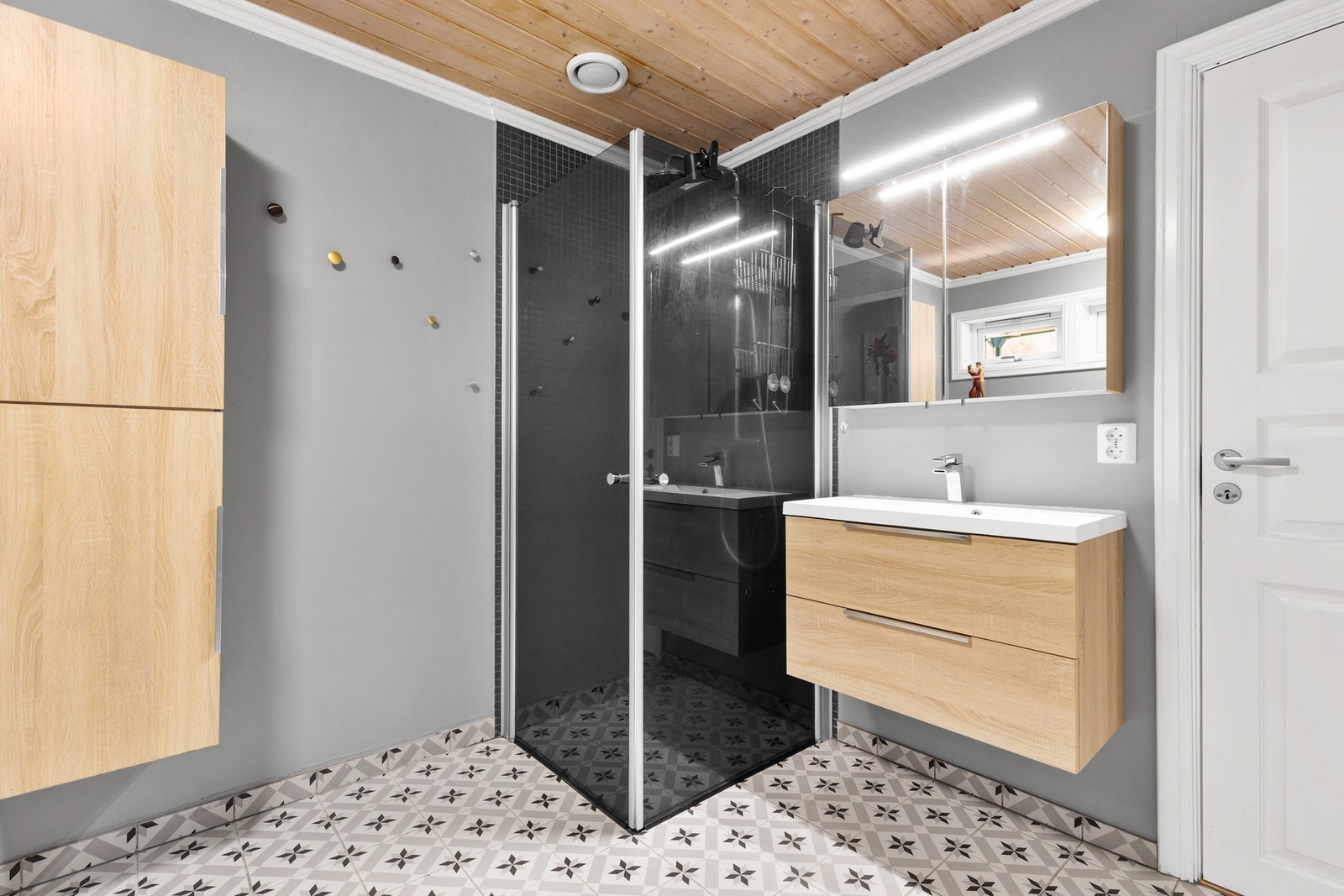 Rommet er innredet med servantinnredning, dusjhjørne med glassvegger og opplegg for vaskemaskin Galleribilde