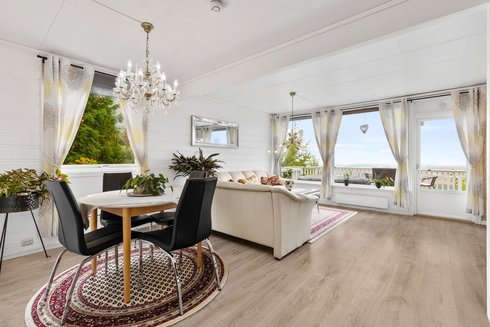 Pen stue med laminatgulv, liggende panel på vegger og takplater i himlingen Galleribilde