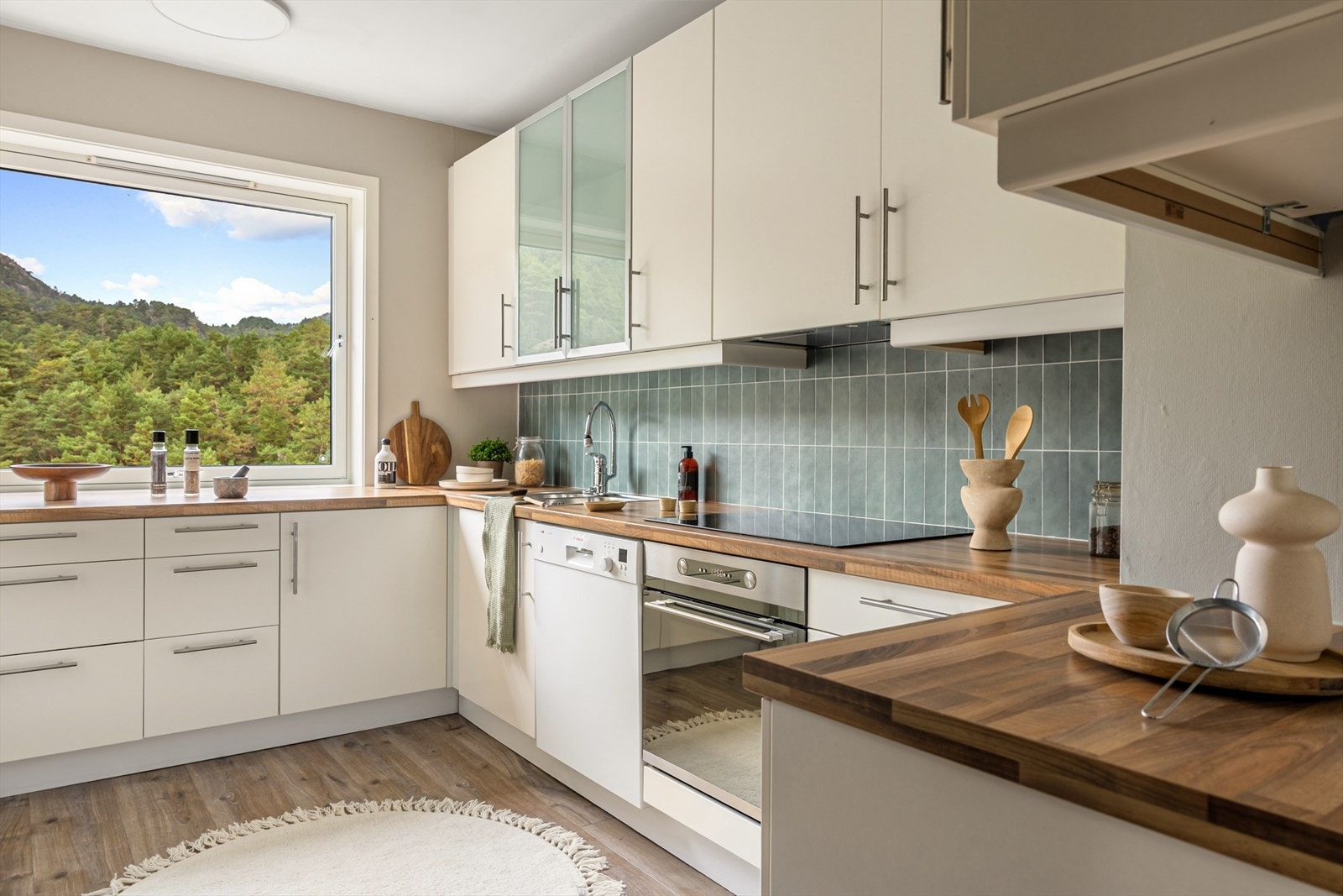 Kjøkkenet har innredning med slette fronter og laminat benkeplate Galleribilde