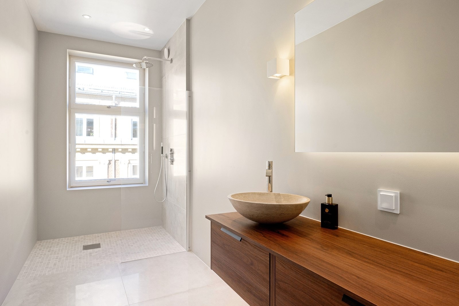 Som resten av leiligheten er badet lyst og delikat i rolige beige toner. Galleribilde