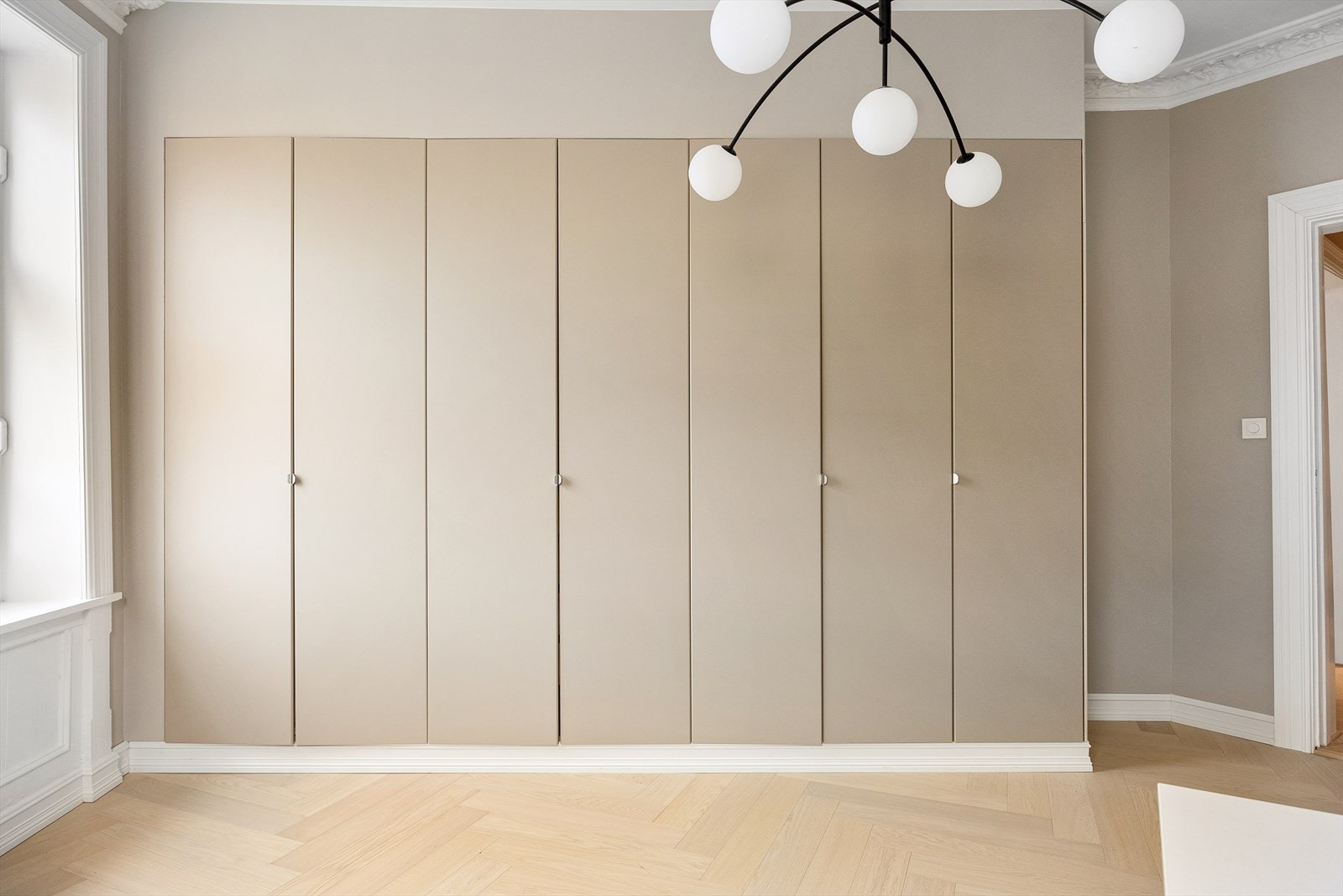 Dette soverommet har et stort garderobeskap langs hele langveggen, malt i samme harmoniske farge som soveromsveggene. Galleribilde