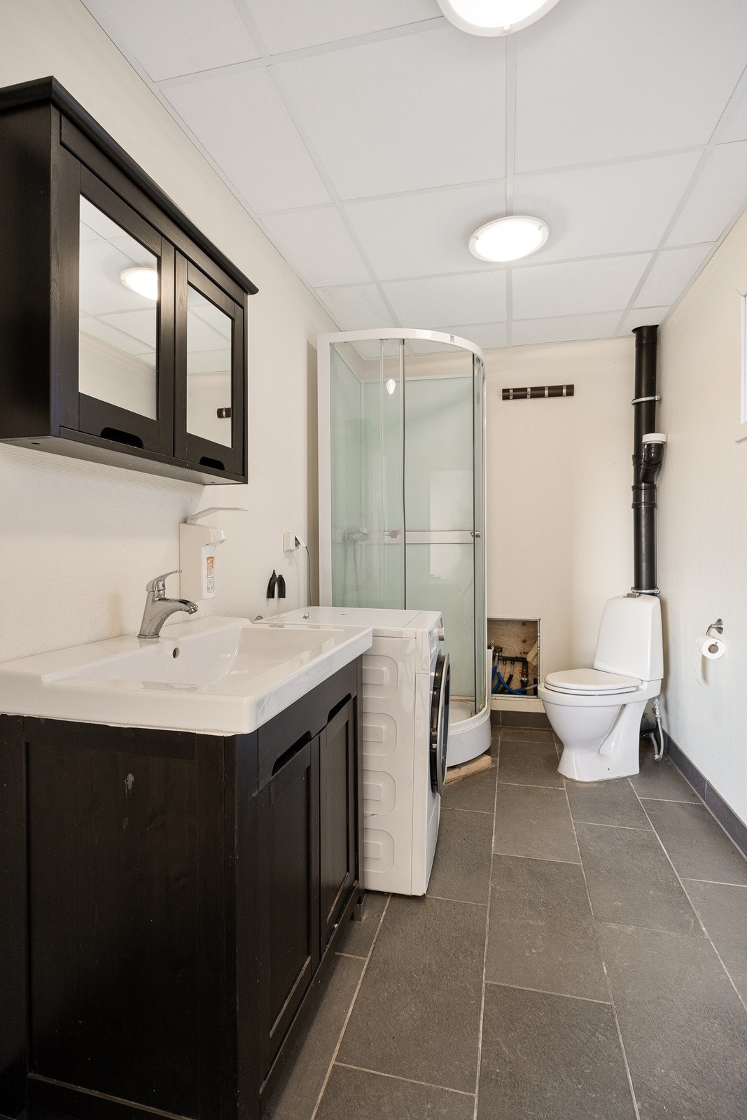 Badet i garasjen er ikke bygget som våtrom og det er ikke sluk i gulvet. Galleribilde