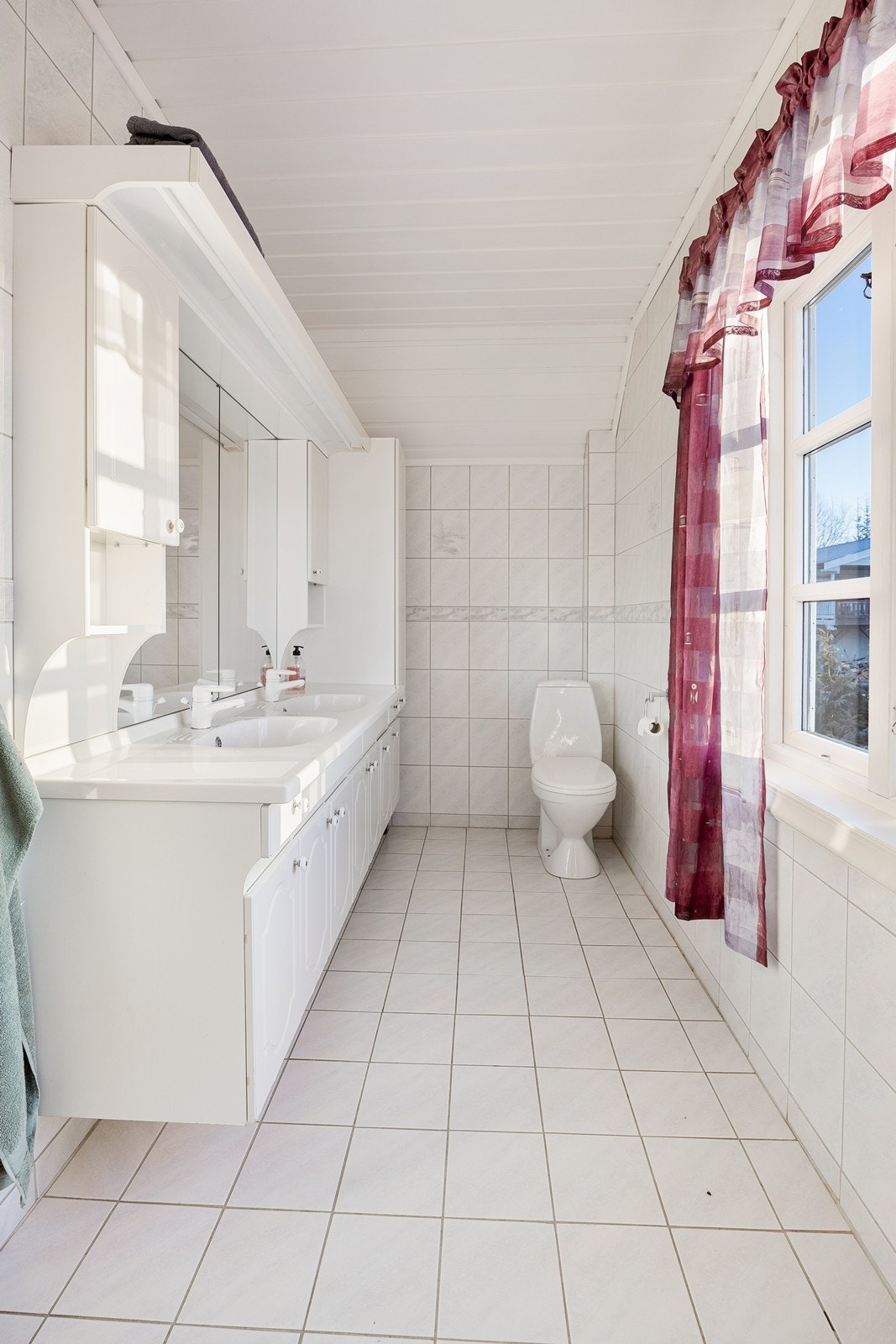 Badet ligger i andre etasje, og har lyse fliser på overflatene, varme i gulvet og naturlig avtrekk. Galleribilde