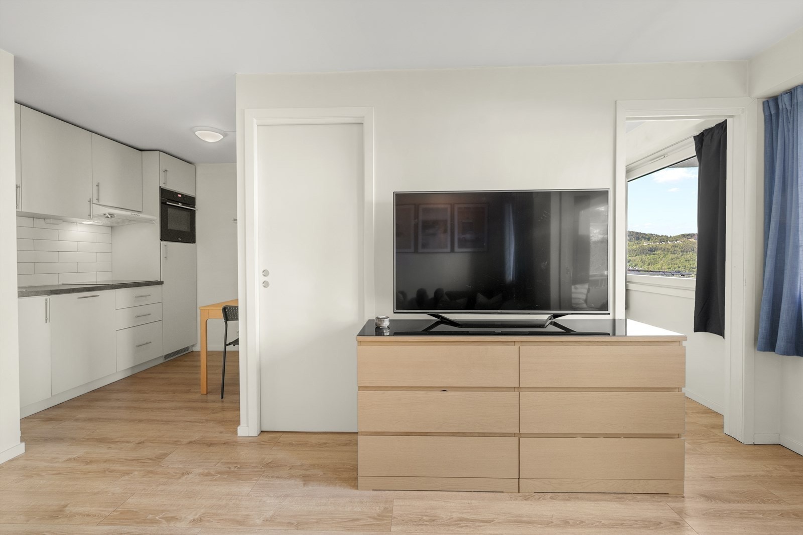 Den åpne løsningen gjør det enkelt å møblere med både en sofa i stuen og spisebord på kjøkkenet. Galleribilde