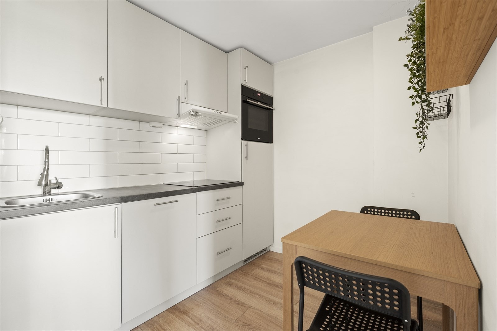 Kjøkkenet fremstår som lyst, pent og tidløst, med glatte fronter og benkeplate i slitesterk laminat. Galleribilde