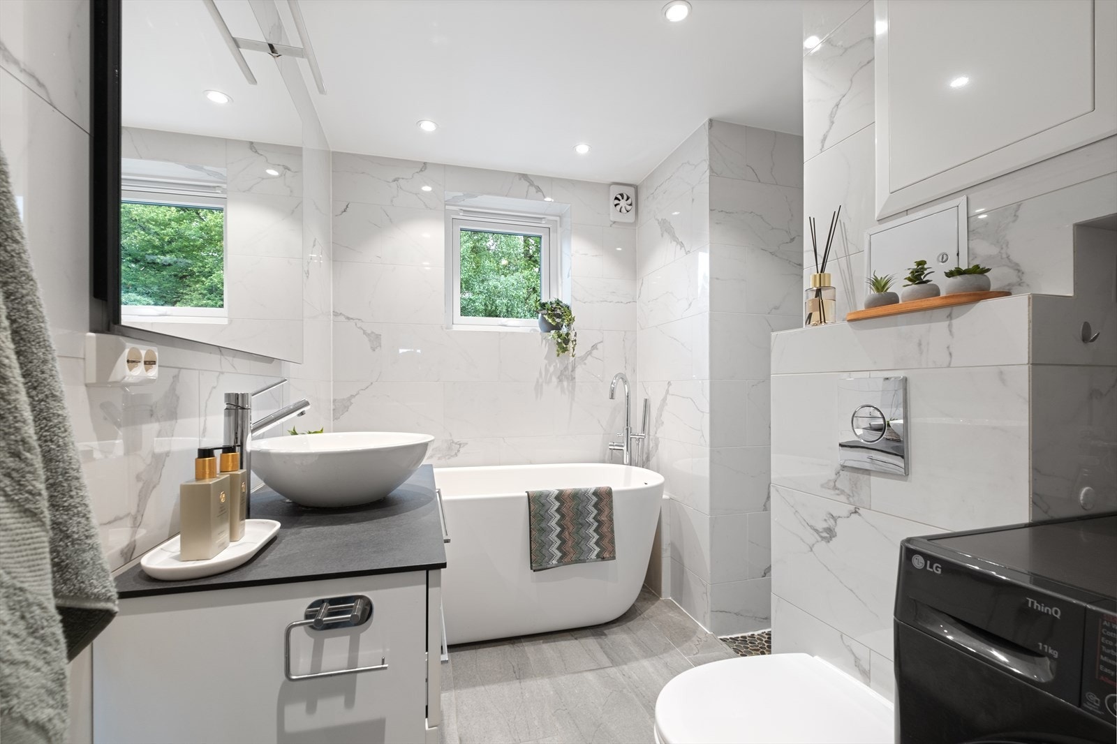 Lekkert, flislagt baderom med elektrisk gulvvarme og himling med innfelte downlights. Galleribilde