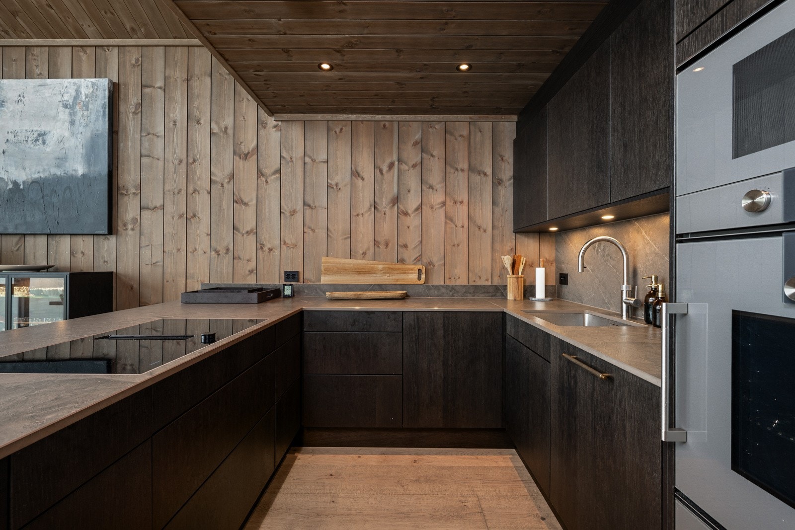 Kjøkkenet er et elegant og gjennomtenkt rom med innredning fra Sigdal (Favn Kongle 2.0), og benkeplate samt back-splash i eksklusive Dekton Kira. Galleribilde