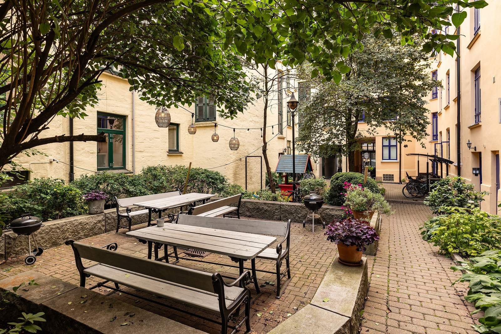Sjarmerende og frodig bakgård med sittegrupper, grill og hyggelige møteplasser. Galleribilde