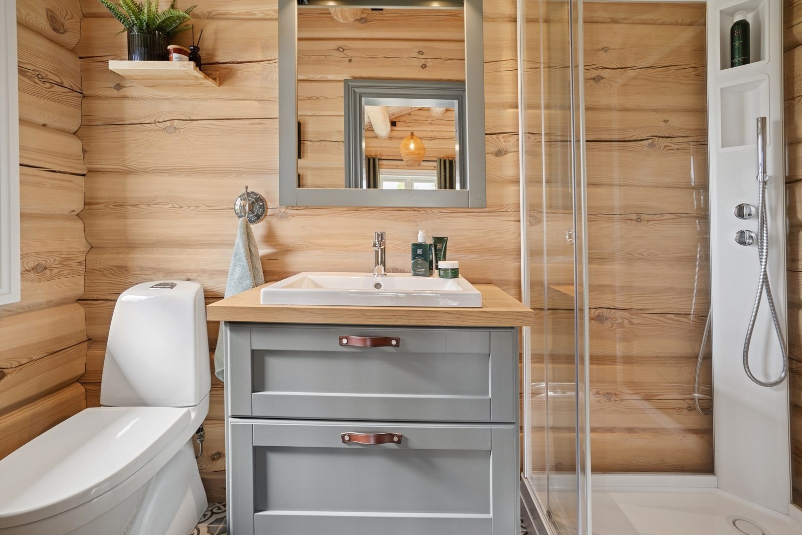 Badet er utstyrt med baderomsinnredning, dusjkabinett og wc. Galleribilde