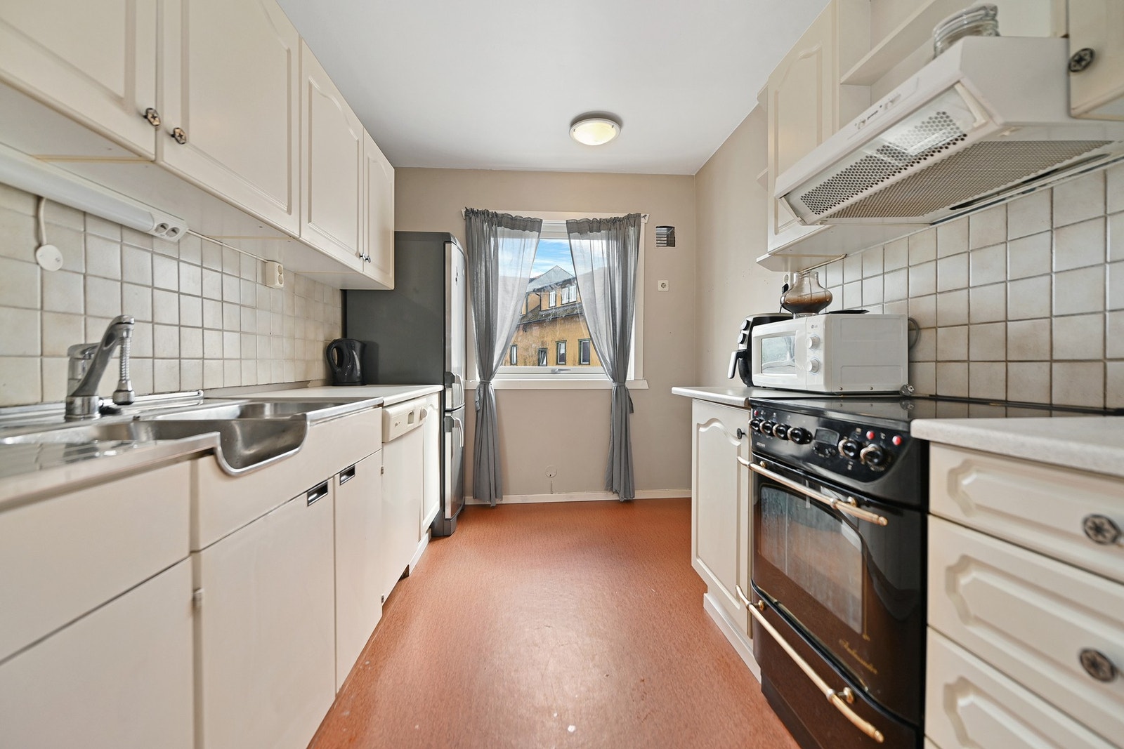 Kjøkken med skap- og benkeplass på begge sider. Galleribilde