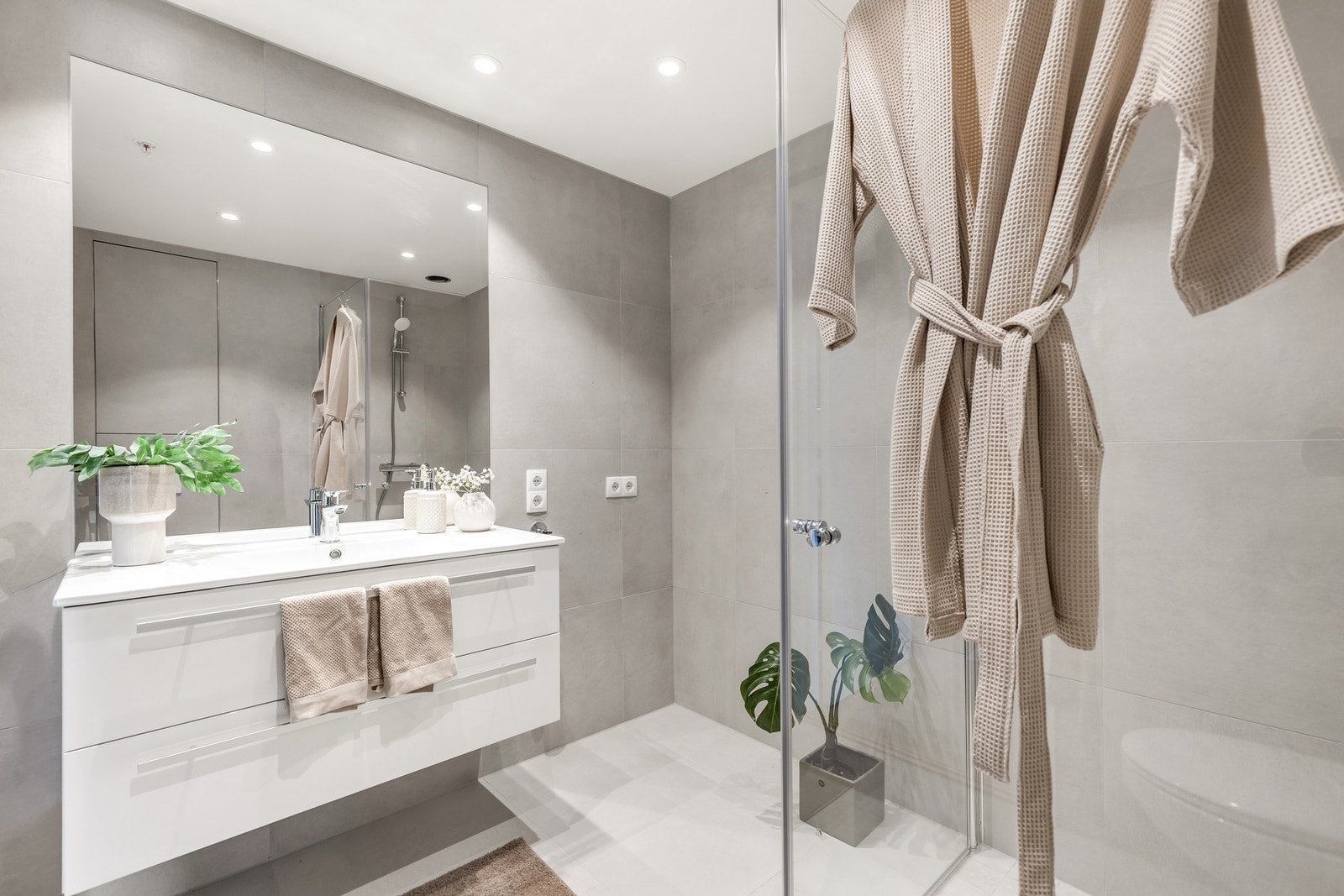 Delikat, flislagt bad med downlights i himling. Bilde tatt fra en tilsvarende leilighet i 1. etasje Galleribilde