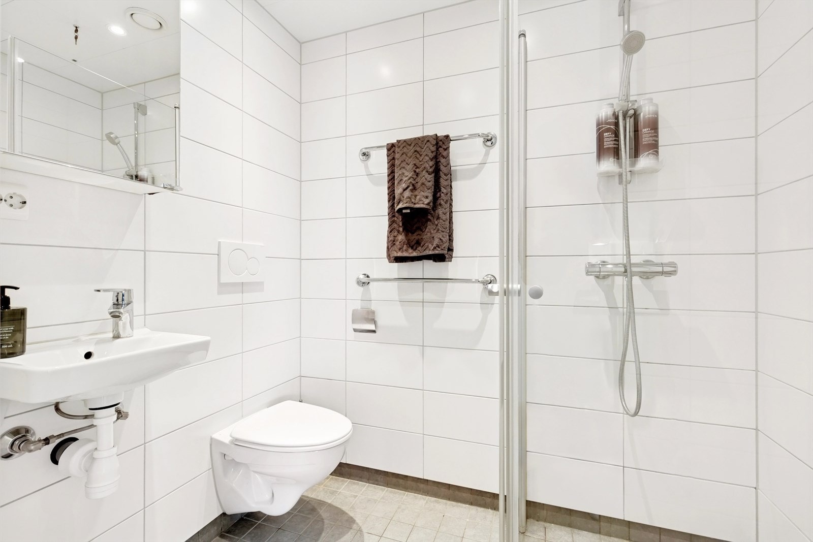 Baderom nr 2 - også dette helfliset med fliser på både gulv og vegger. Innredningen består av servant, overskap med speildør, vegghengt toalett og dusjhjørne med svingdører. Galleribilde