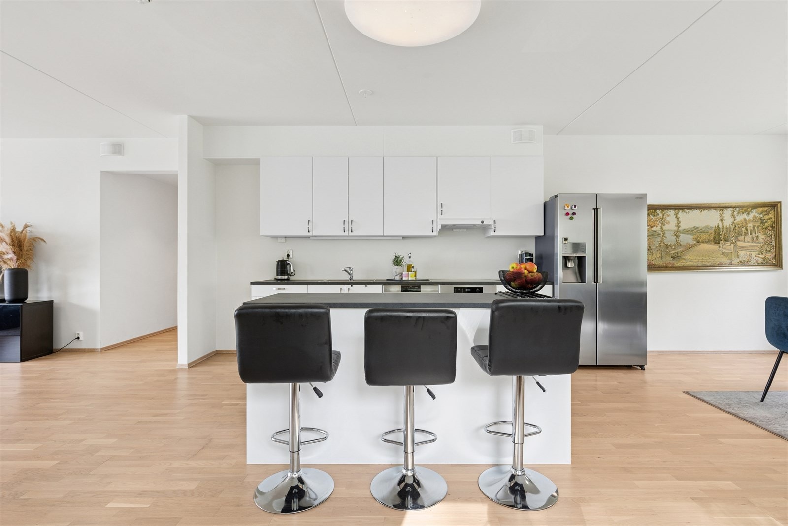 En romslig kjøkkenøy gir ekstra benkeplass og har plass til barstoler. Galleribilde