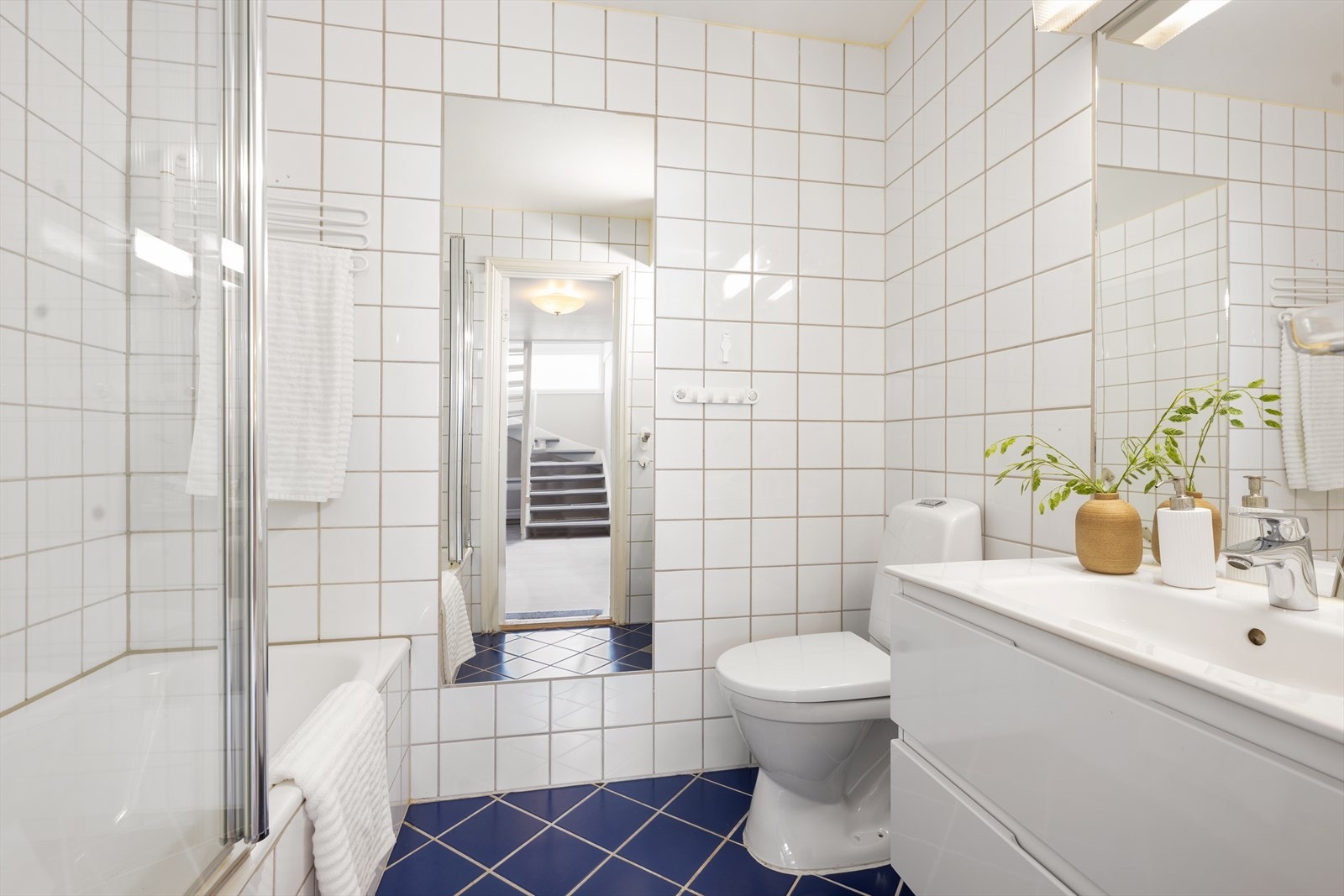 Lys og pent bad i underetasjen, innredet med badekar toalett og servant i skuffeinnredning. Galleribilde