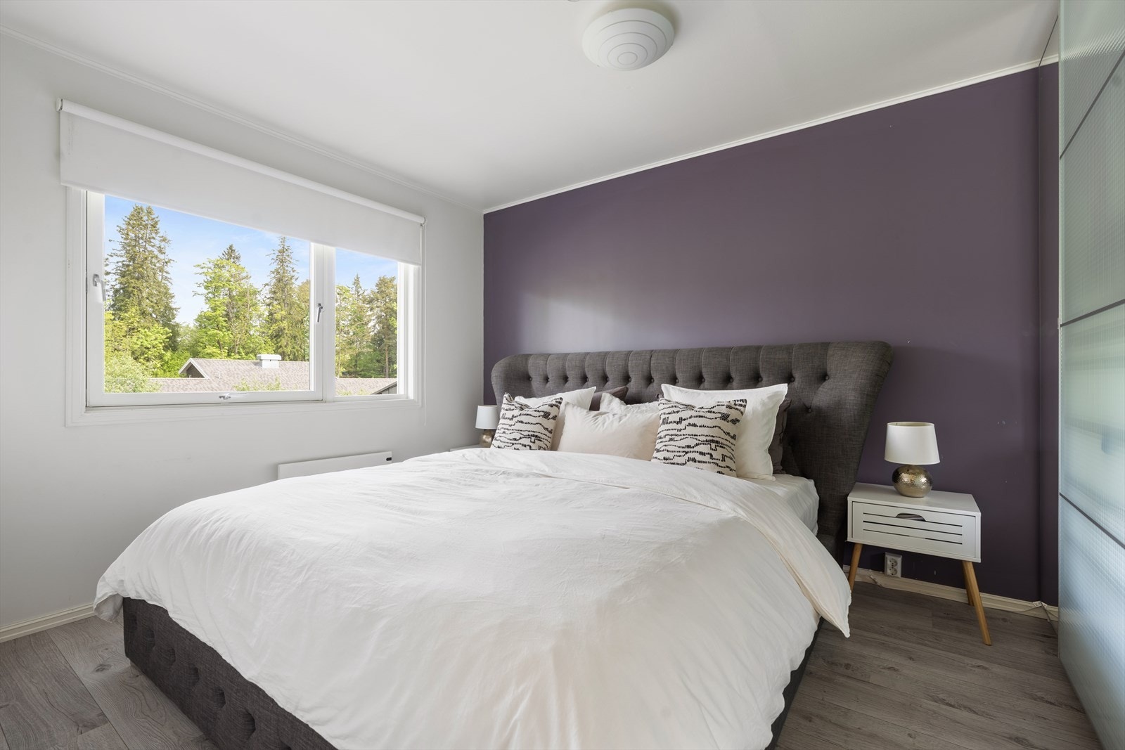 Boligen har tre gode soverom - her er et av de to soverommene som ligger i 1.etasje. Her er det god plass til dobbeltseng og nattbord i tillegg til stor skyvedørsgarderobe. Galleribilde