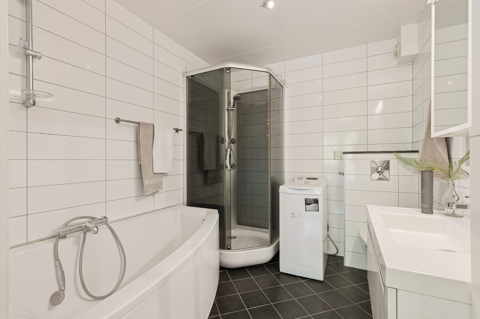 Badet er ellers utstyrt med dusjkabinett, badekar, veggehengt toalett, servant med skuffer under og speilskap. I tillegg har man opplegg for vaskemaskin. Galleribilde