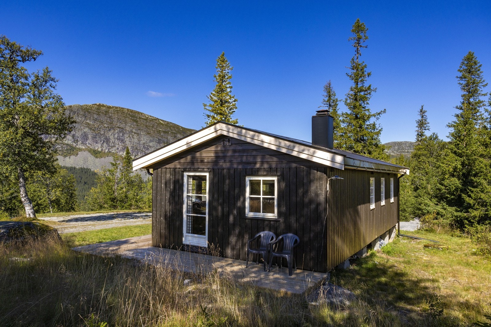 Eiendommen ligger på en naturskjønn skogstomt, omkranset av frodig vegetasjon og trær som gir en rolig og privat atmosfære. Galleribilde
