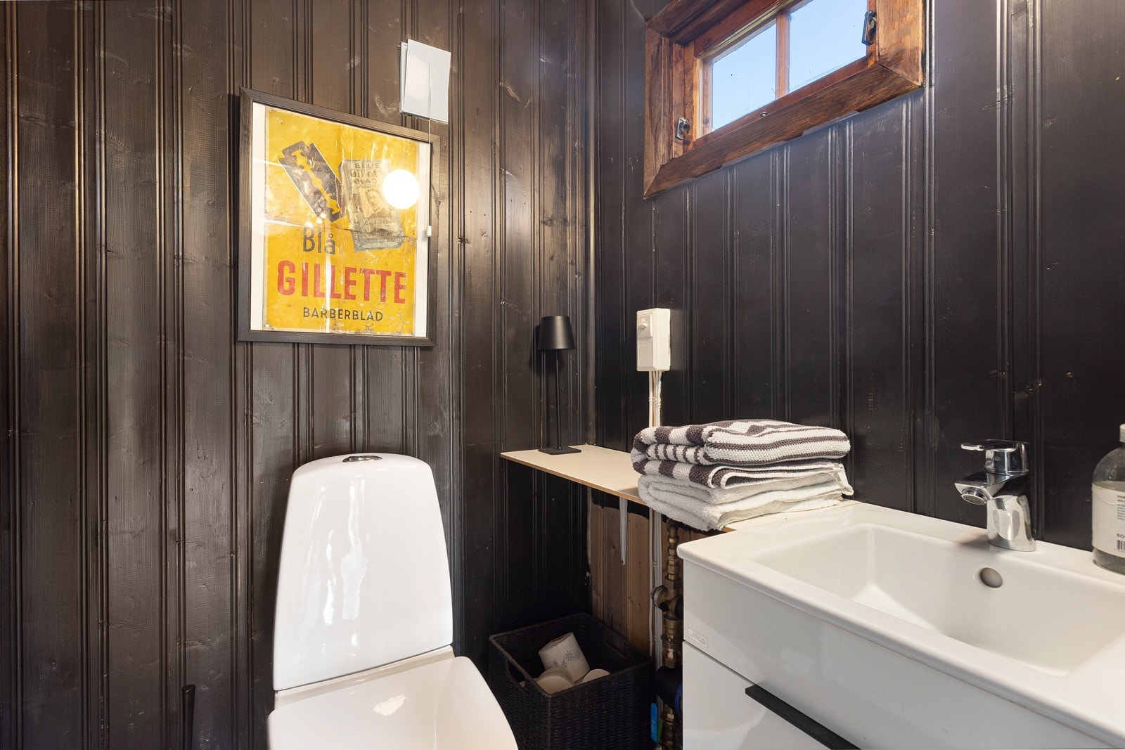 Eget toalettrom med elvestein på gulv og panel på vegger og tak. Rommet har servant og fremstår som en praktisk løsning, særlig ved besøk. Galleribilde