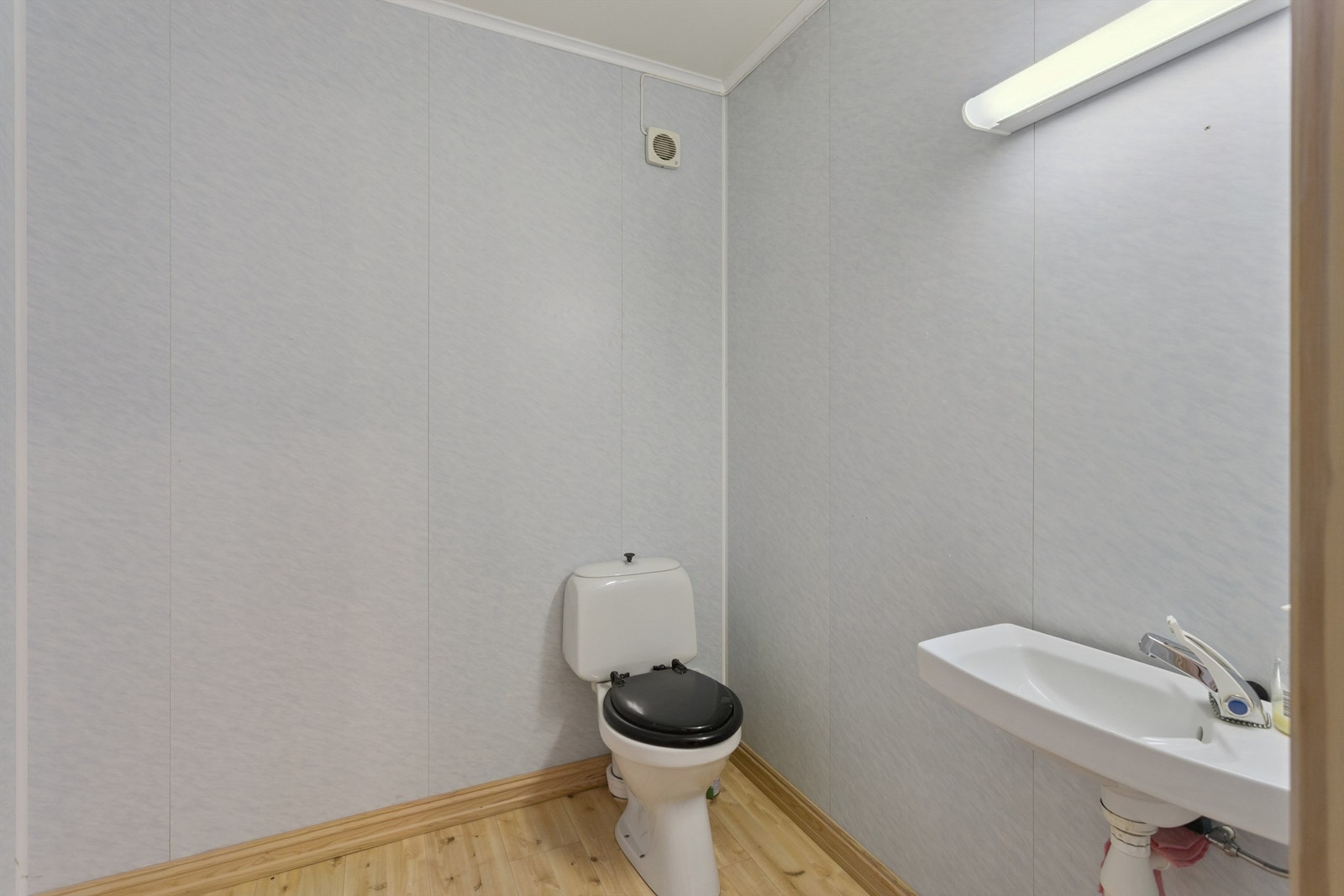 Romslig toalettrom med servant og gulvmontert WC i første etasje. Galleribilde