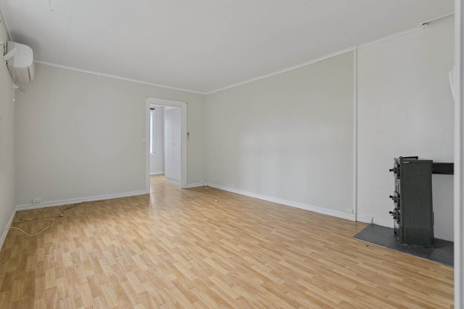 Leilighet i 2. etasje - Stue med varmepumpe og en eldre koksovn- Ett vindu mot sør. Galleribilde