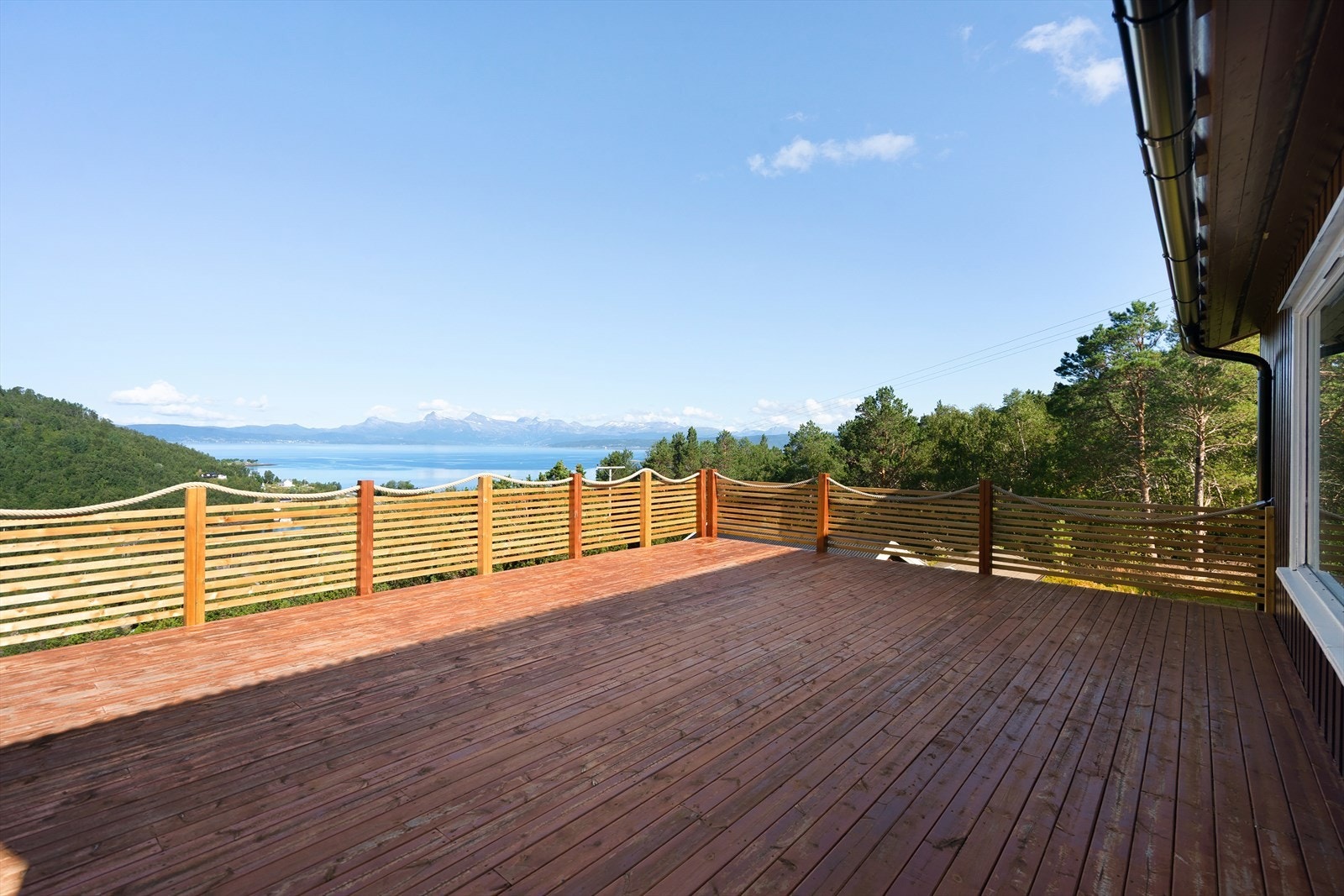 Fra veranda har du flott utsikt - både til sjøen, fjellene og grønne omgivelser Galleribilde