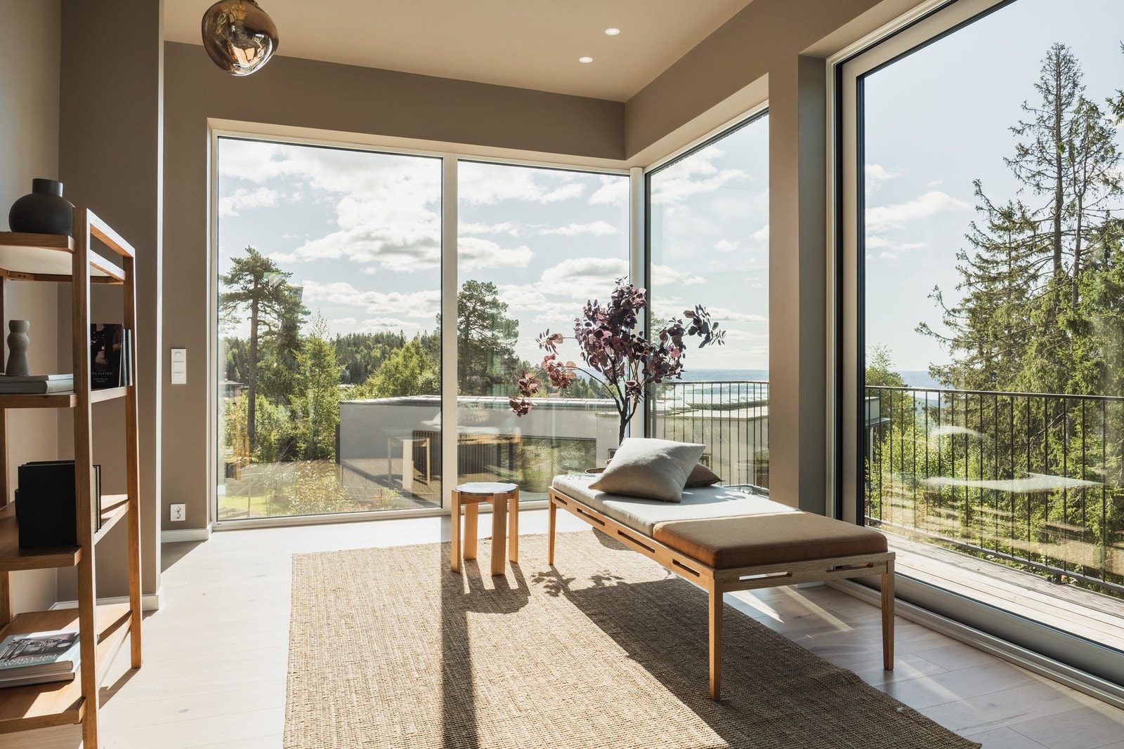 Store vindusflater fra flere sider skaper en lys og hyggelig atmosfære i rommet. Galleribilde