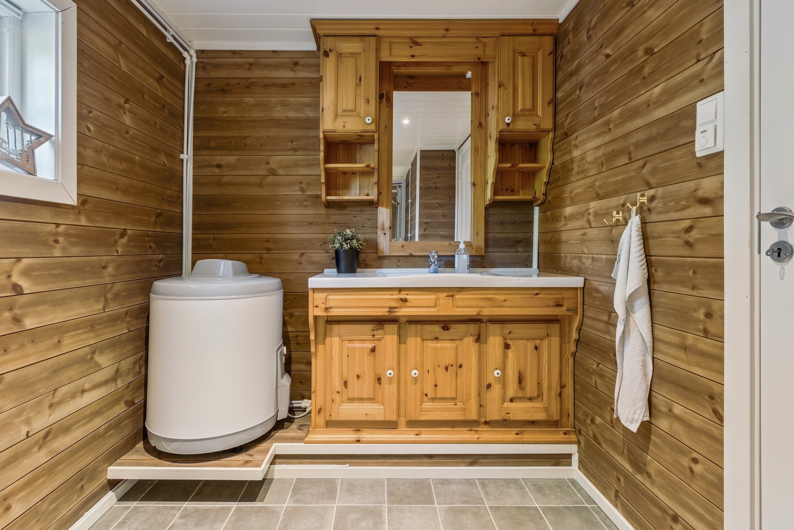 Badet inneholder servant, speil, skap, wc og dusjkabinett. Varmekabler i gulv. Galleribilde