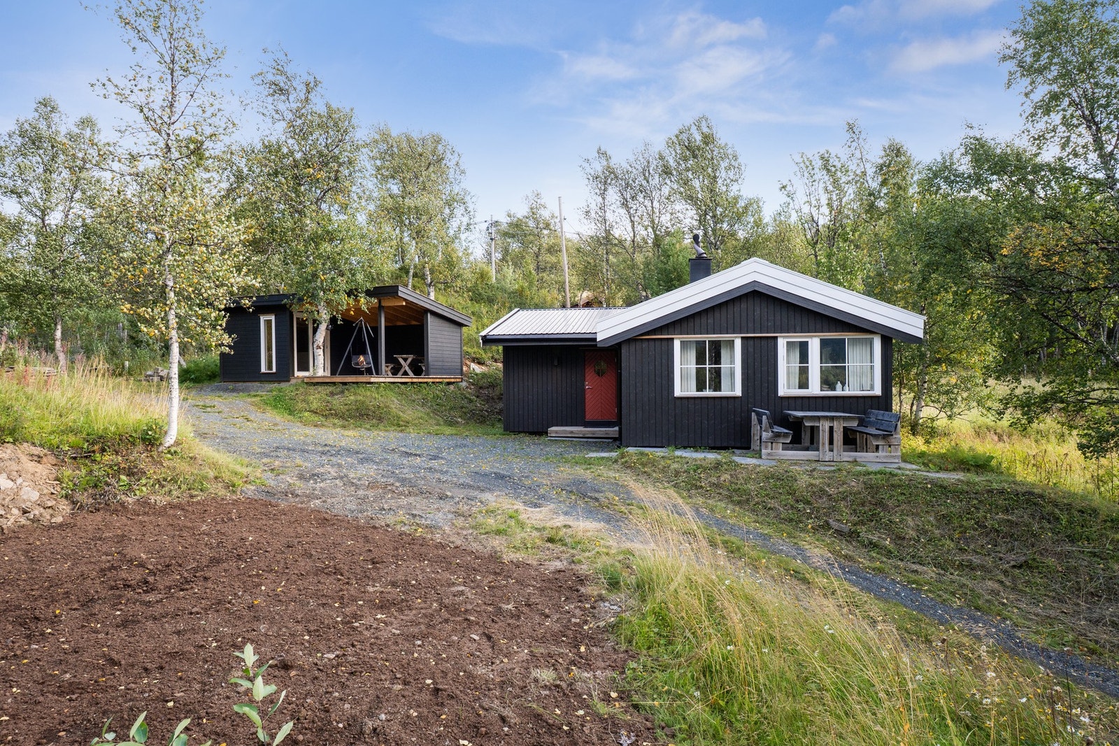 Pent opparbeidet fasade og uteområde. Privat vei opp til hytta. Galleribilde