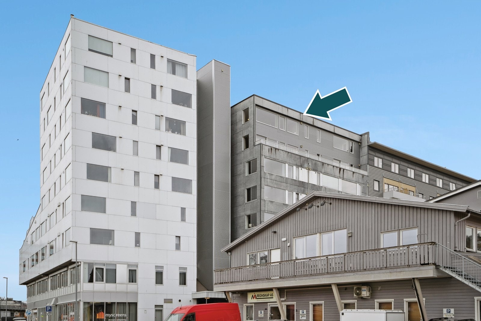 Fasade sett fra nordsiden, leiligheten ligger i den grå blokka til høyre på bildet, og deler heis- og trappehus med den hvite blokken. Inngang fra både sør og nord til heishuset. Mulighet for å leie parkering i garasjeanlegg. Galleribilde