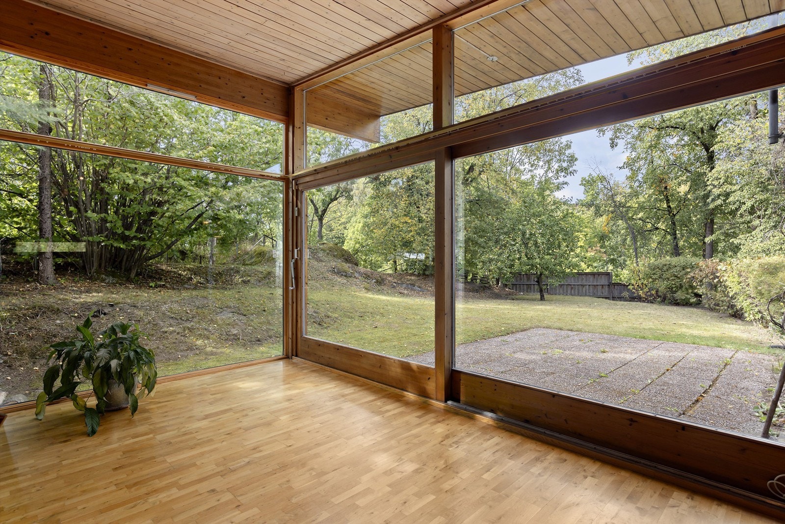 Store vindusflater i stuen med utgang til hage og uteplass. Galleribilde