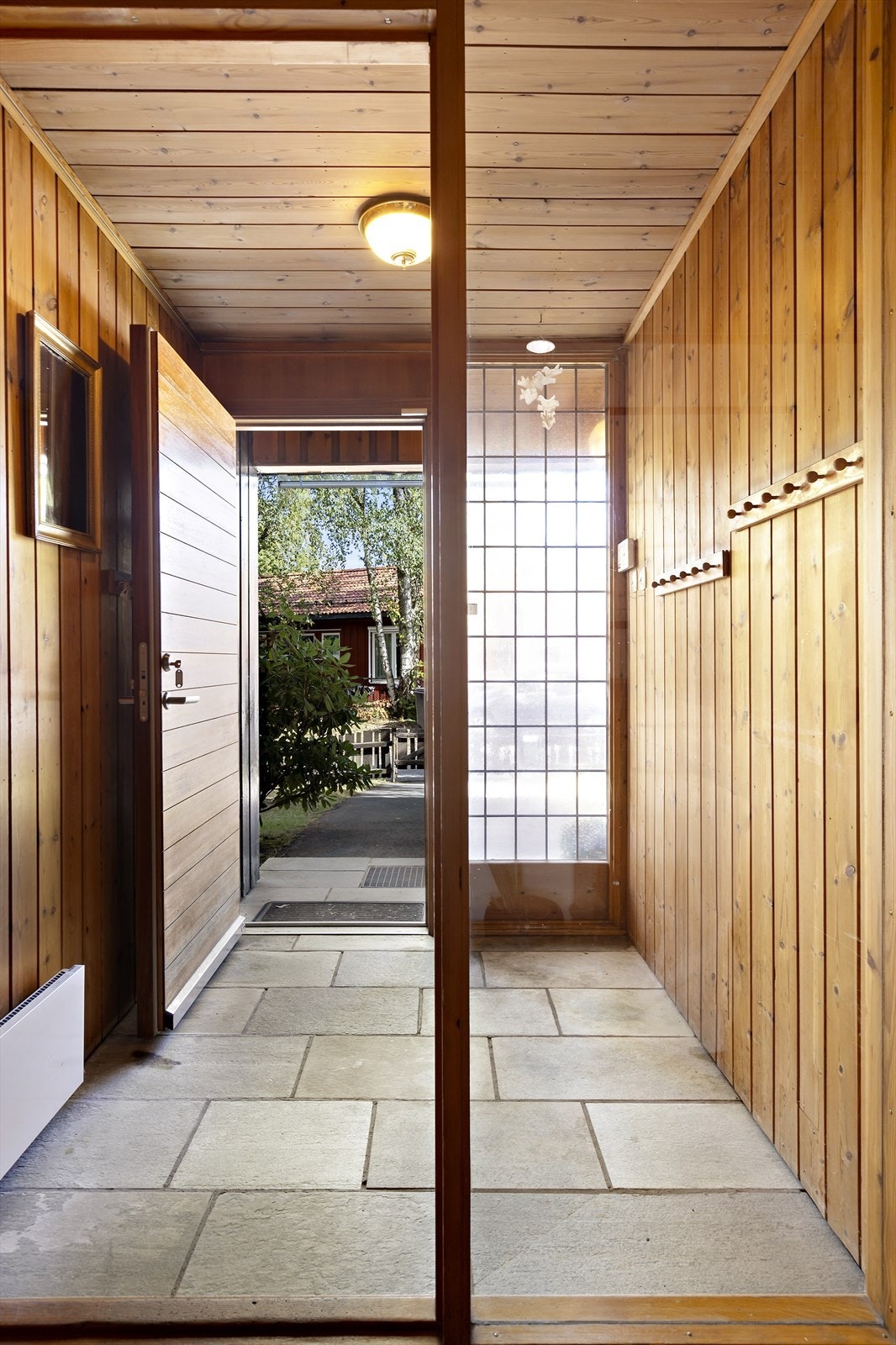 Skiferbelagt entré/hall med blyvindusvegg. Ytterdør fra nyere tid. Galleribilde