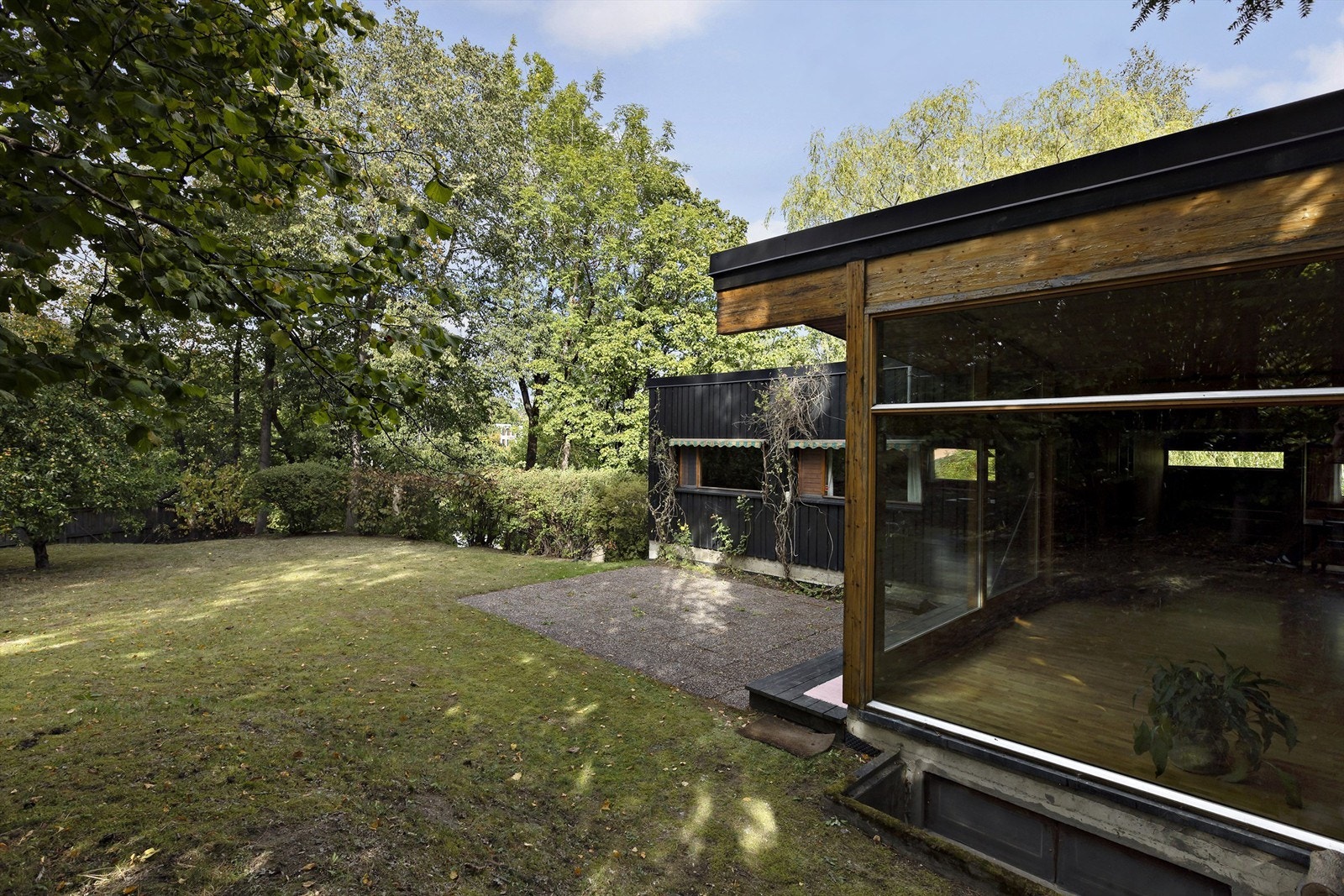 Stor hage med uteplass, busker og trær. Galleribilde