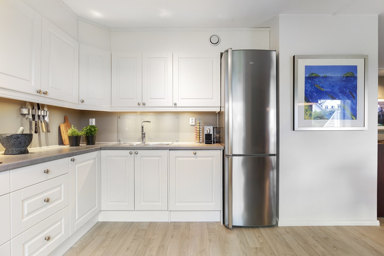 Kjøkkenet er utstyrt med hvitevarer som stekeovn med induksjonsplatetopp, kjøl/fryseskap og oppvaskmaskin. Galleribilde